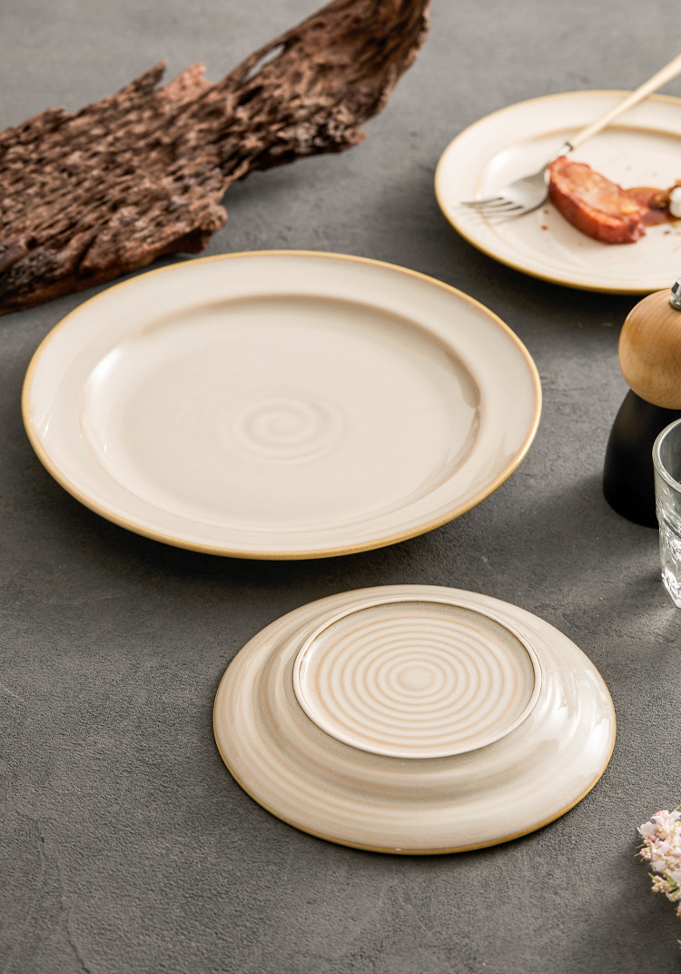 High-contrast food photography of a petite floral garnish on a cloud-patterned dish.