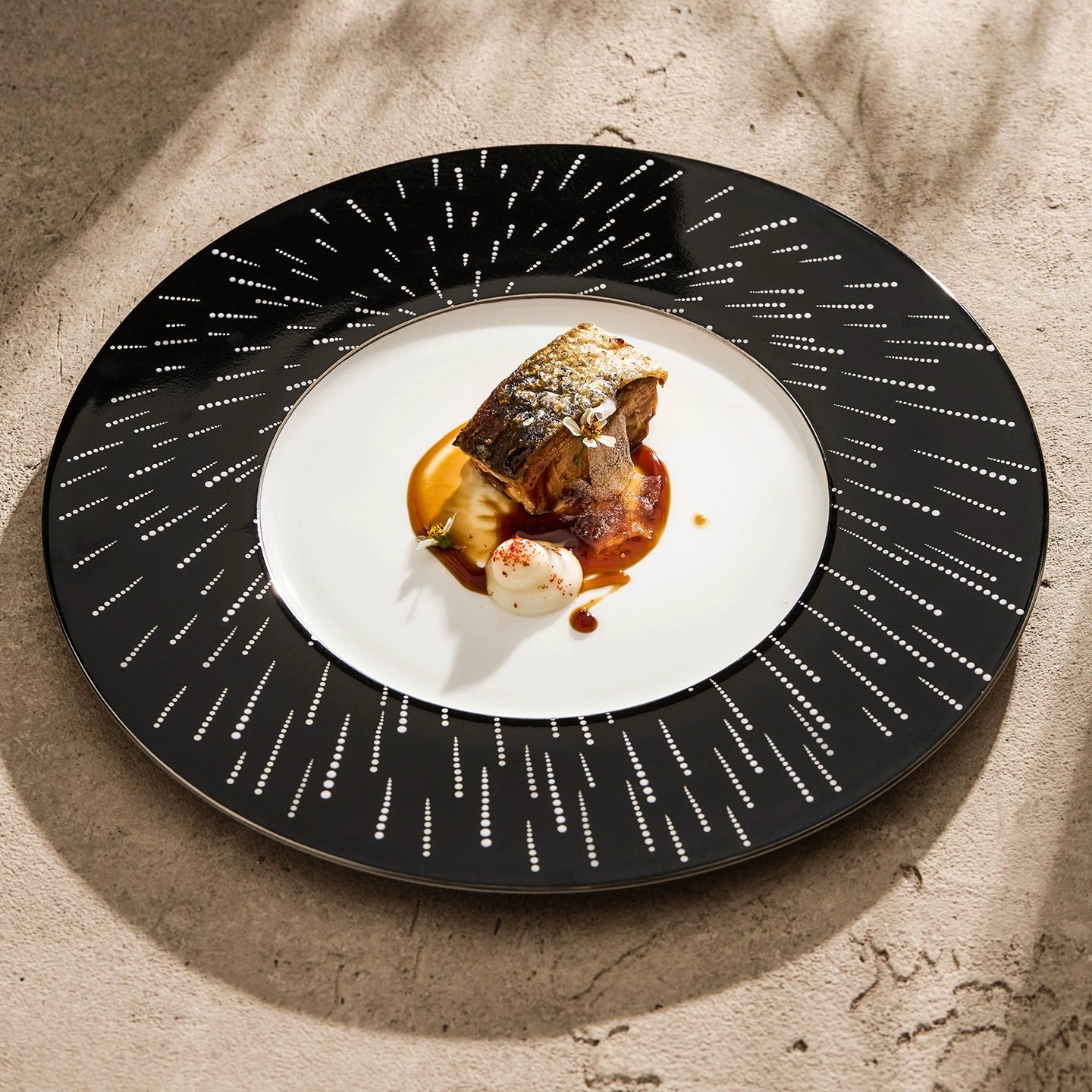 High-contrast table setting with a midnight-black "Starry Night" artisan dinner plate.