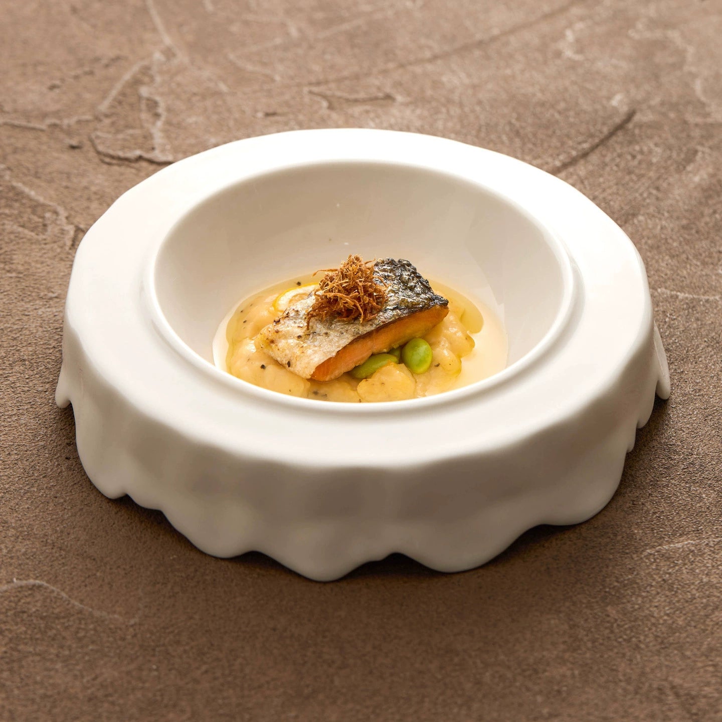 High-temperature porcelain plate with matte white finish and artistic edges.