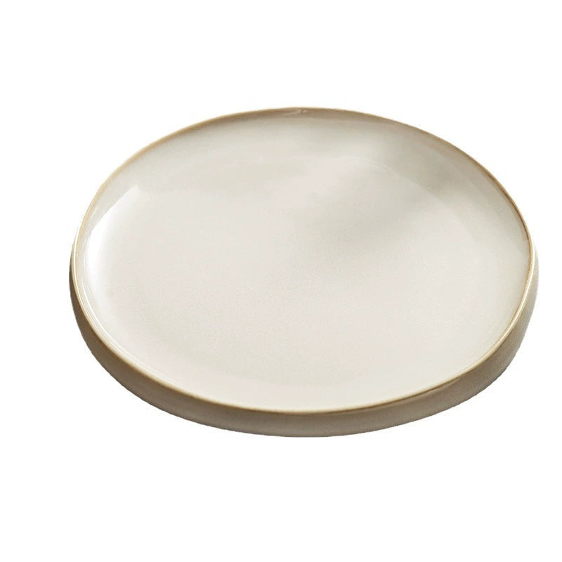 Round ceramic plate with a beige rim on a white background