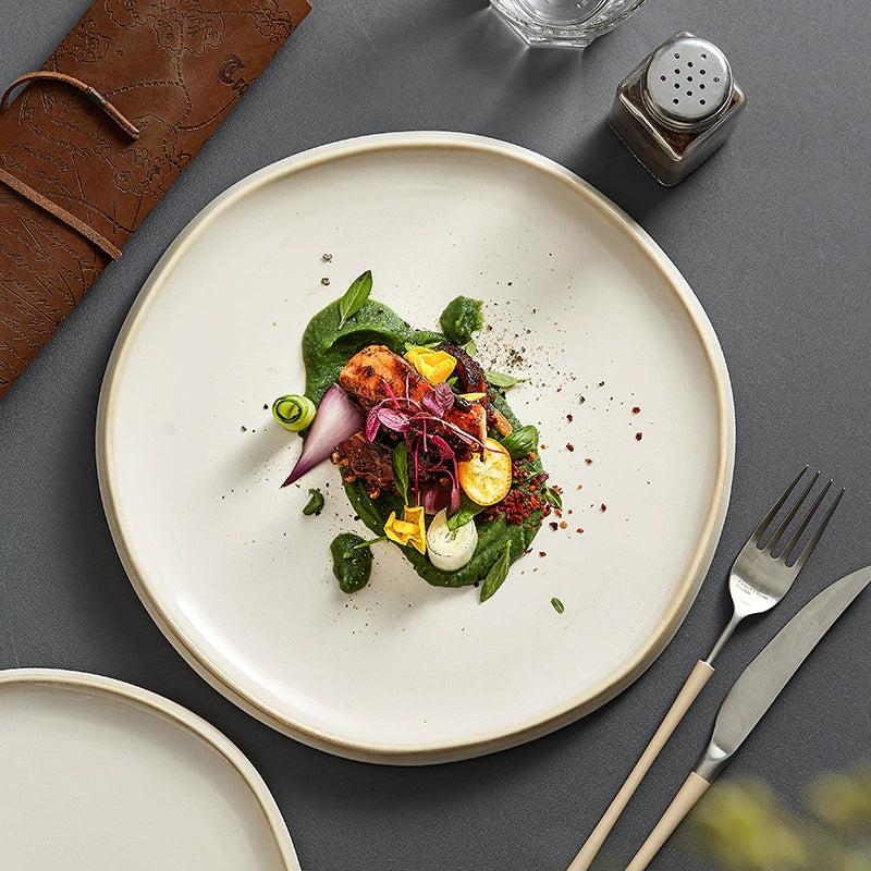 Plated dish of salad on a gray surface with cutlery and a salt shaker.