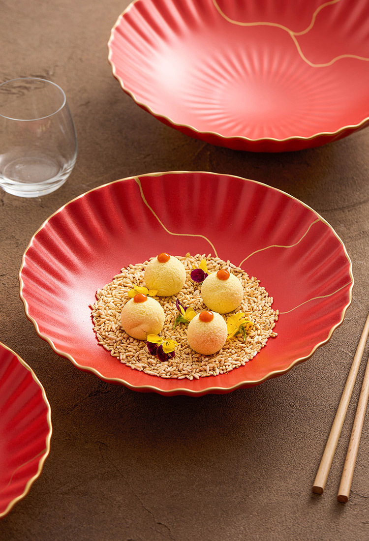 Red decorative plate with a dish of food on a brown surface