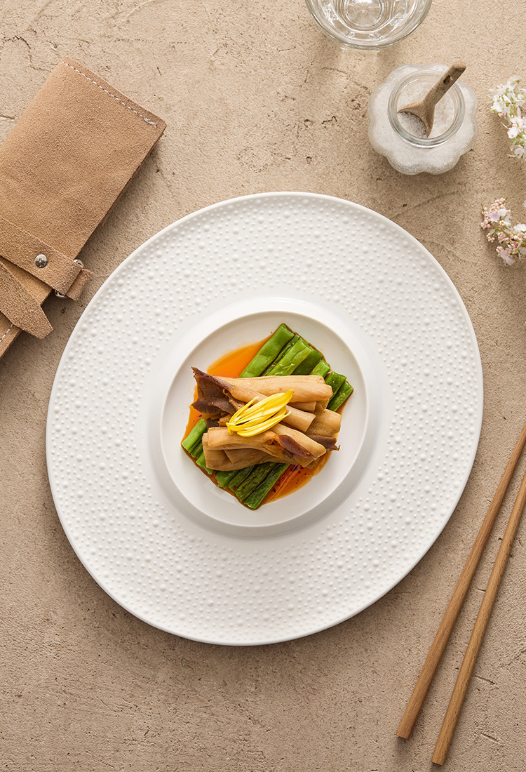 Large white porcelain dinner plate with textured rim and smooth central surface