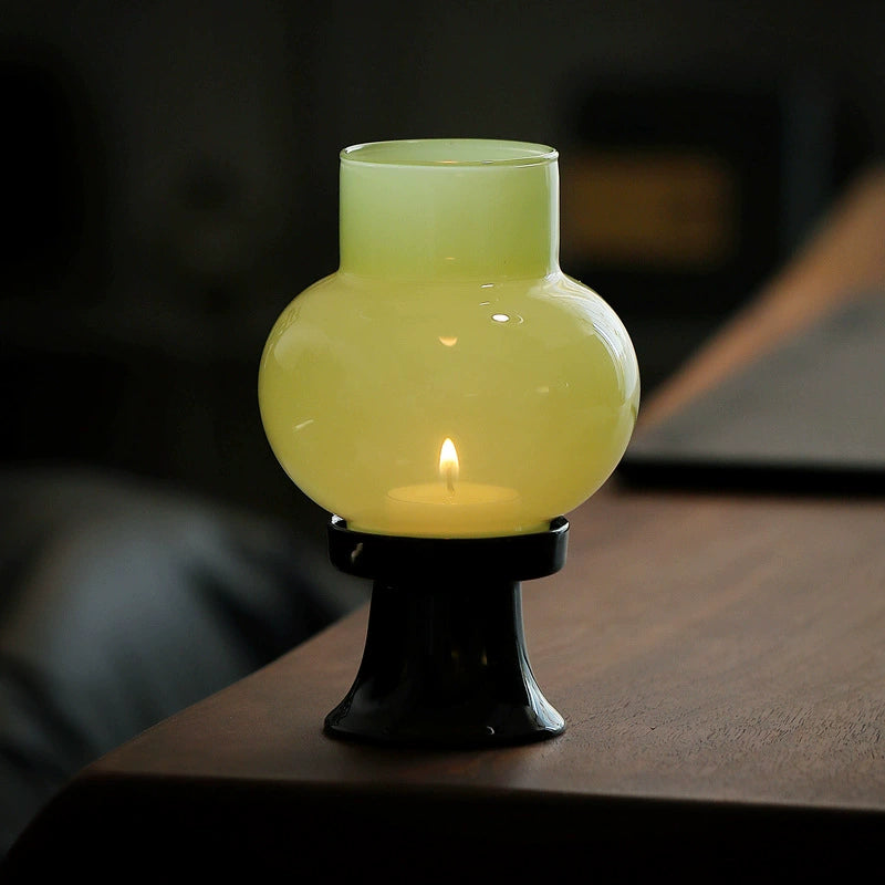 Lavender pink glass candle lamp with elegant ceramic base and gentle glow.