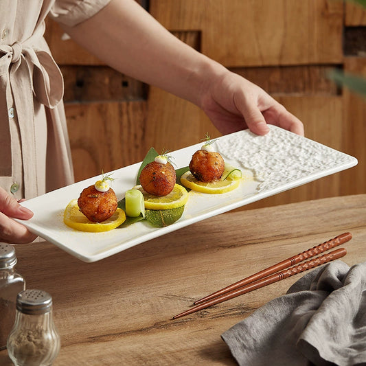 Long ceramic serving plate with artisan edge design

