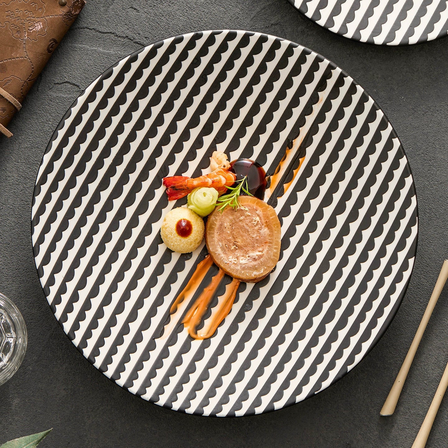 Gourmet dish on a black and white patterned plate with a dark background