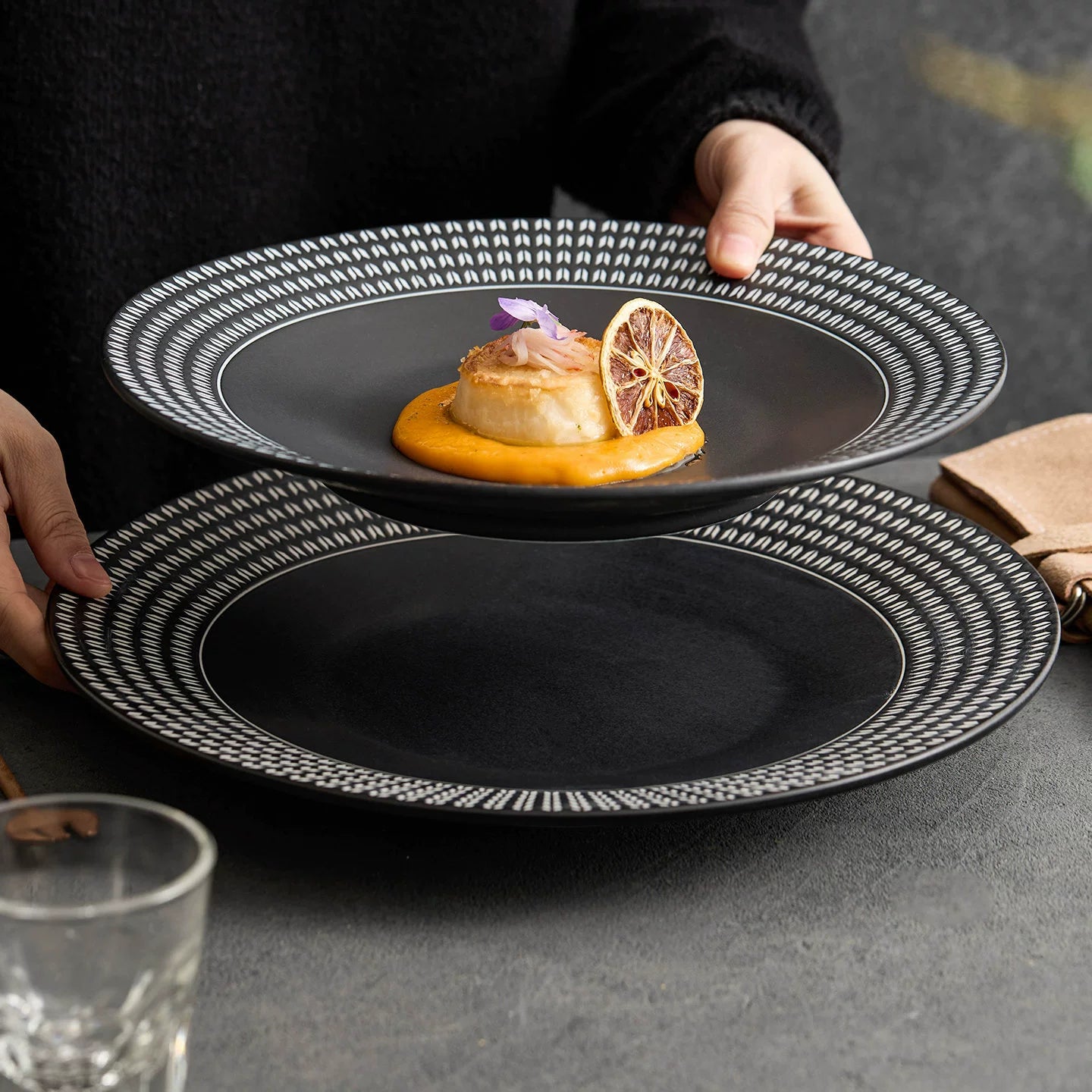 Luxury matte black porcelain plate with a shallow basin and architectural chain-link rim design.