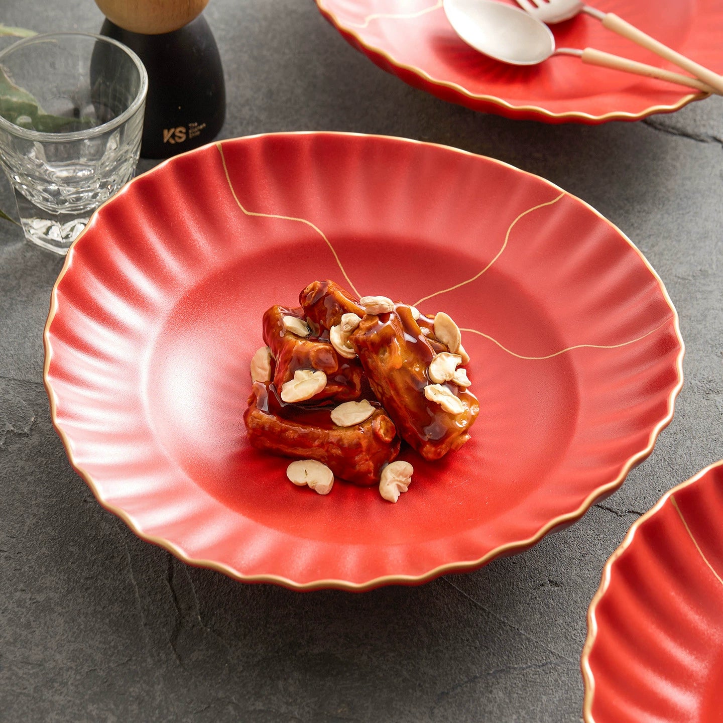 Red plate with food on a dark surface