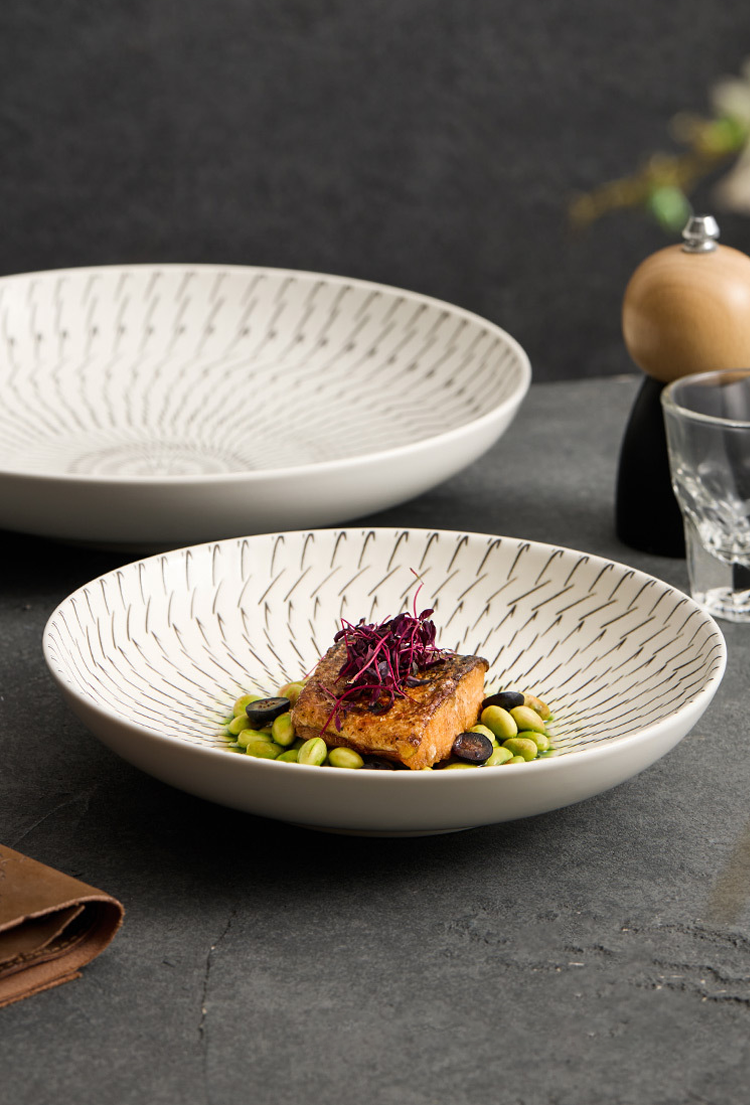 White ceramic bowl with a dish of food on a dark surface