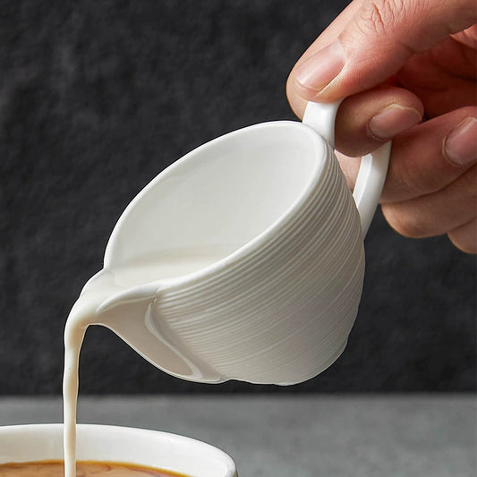 Minimalist ceramic creamer with eagle-beak spout


