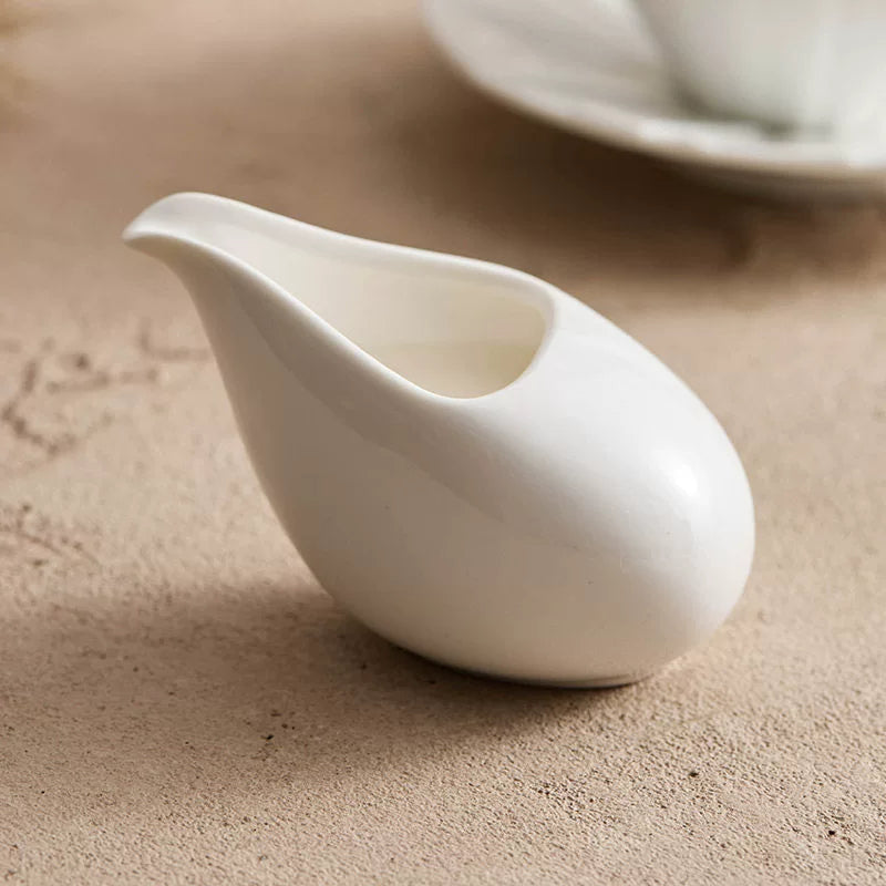 Minimalist pebble-shaped white ceramic creamer from GOSEUNG Tableware Collection.
