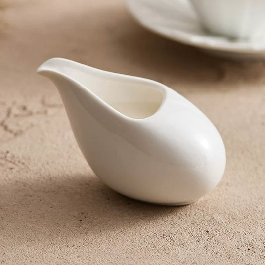 Minimalist pebble-shaped white ceramic creamer from GOSEUNG Tableware Collection.