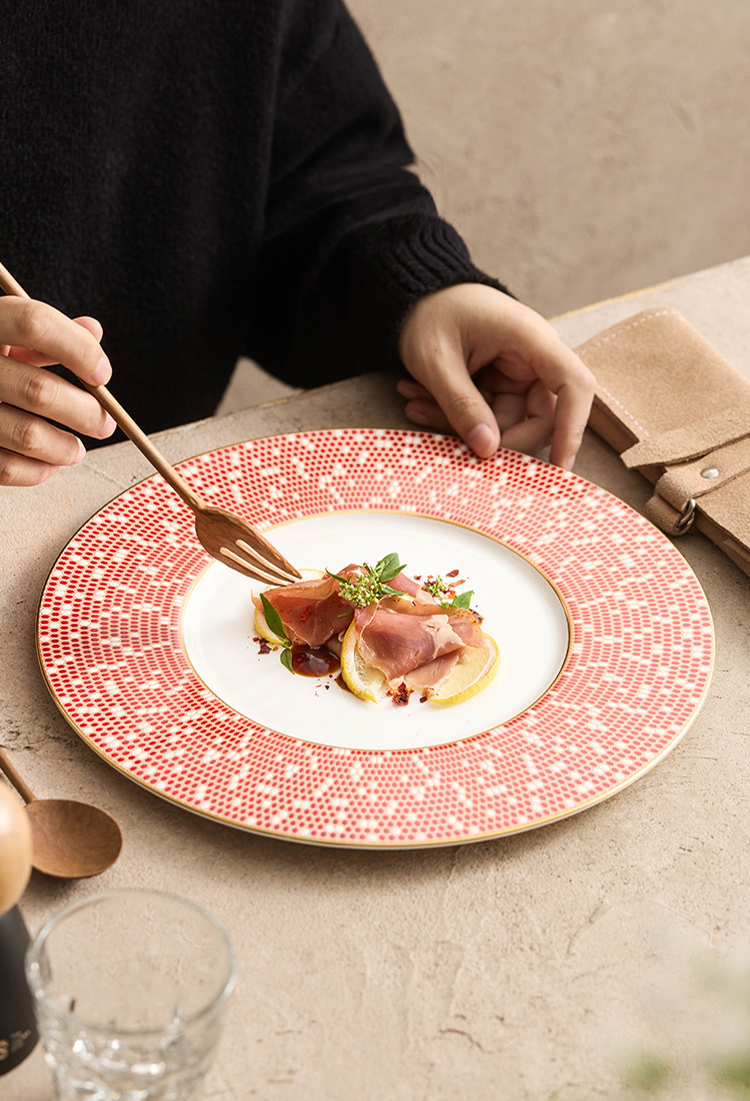 Minimalist white center dinner plate framed by a dense, shimmering red mosaic border.
