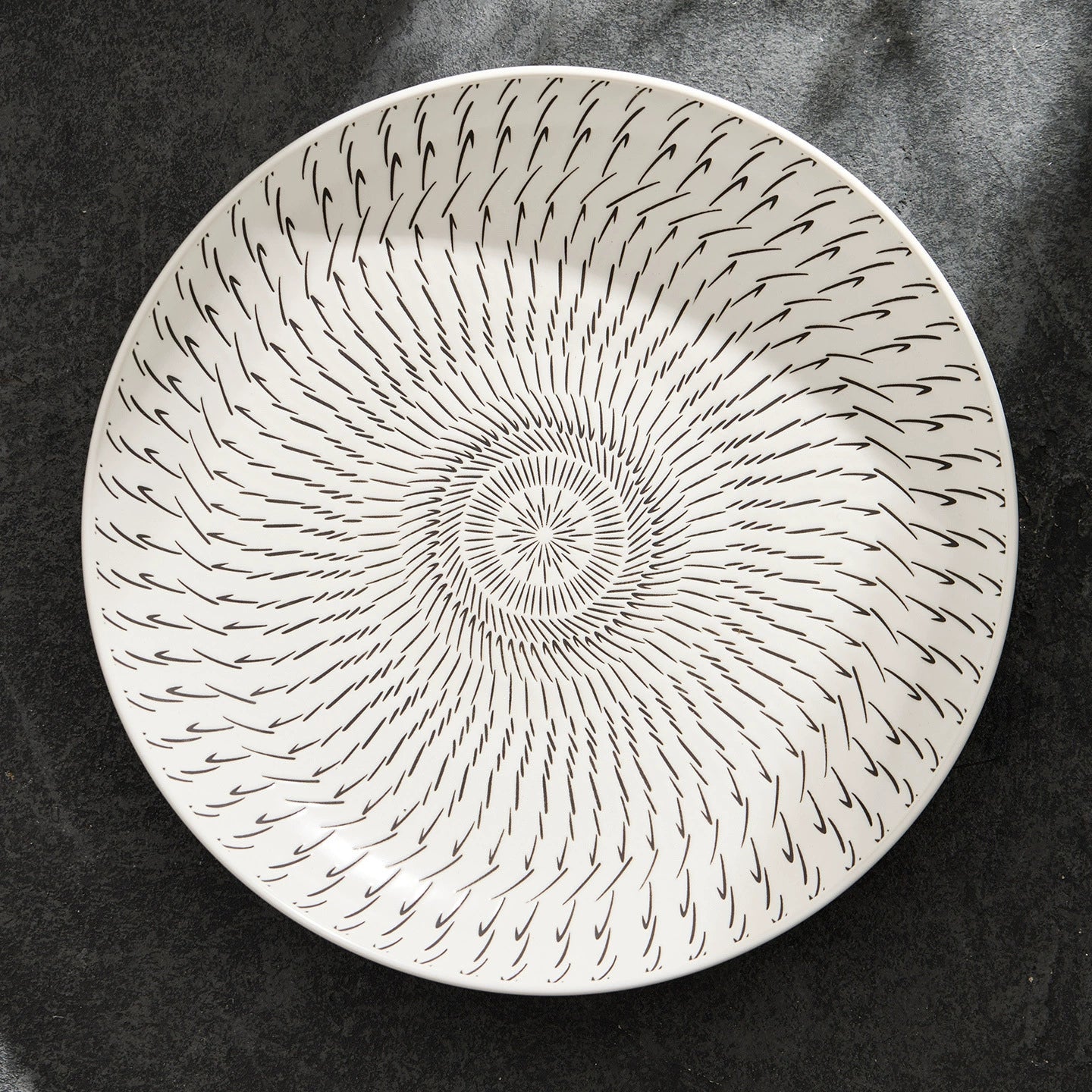 Decorative plate with concentric circular pattern on a dark background