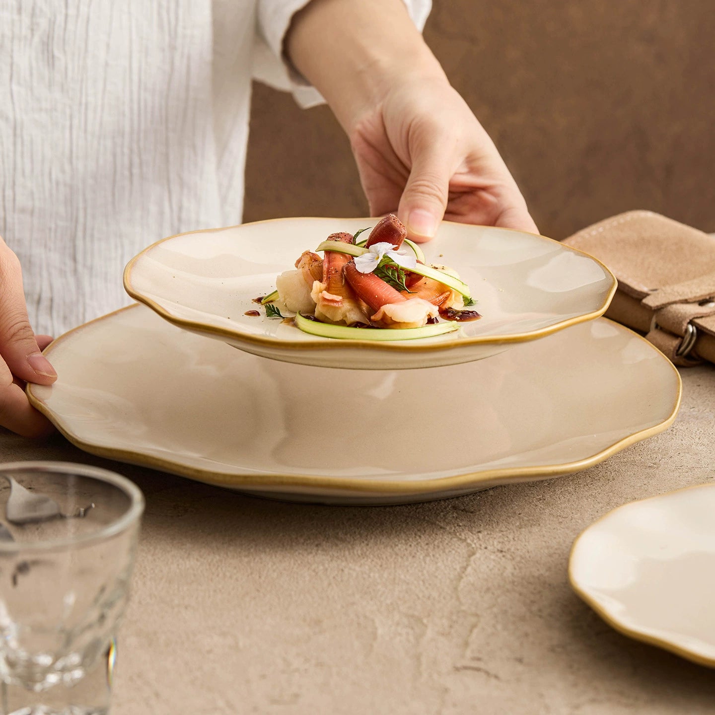 Modern ceramic plate with an organic undulating border inspired by the gentle rhythm of shoreline waves.