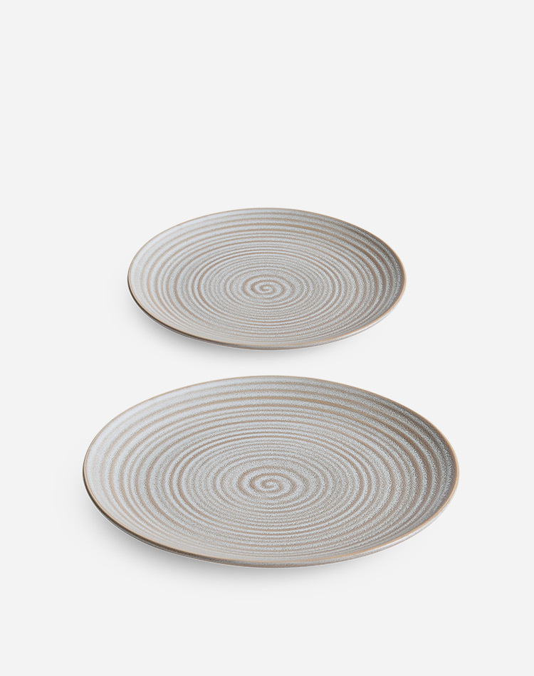 Modern ceramic table setting with textured wave pattern and artisanal tone