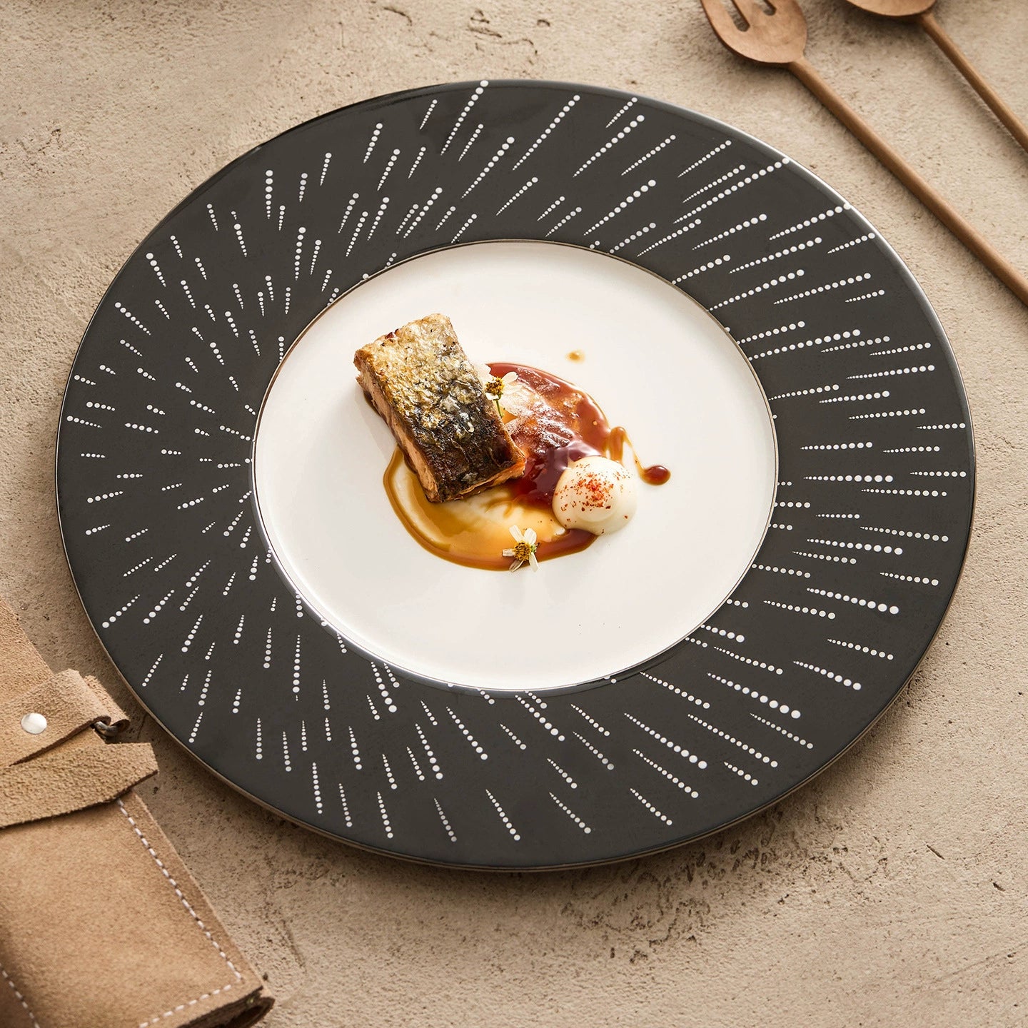 Modern circular porcelain plate with a wide black rim featuring a white stardust pattern.
