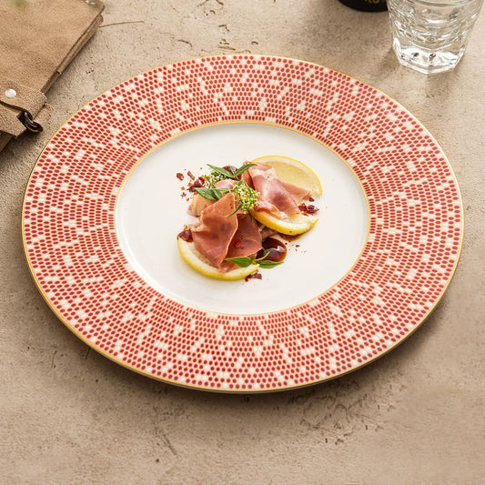 Modern porcelain dinner plate with a wide red mosaic-patterned rim and gold trim.