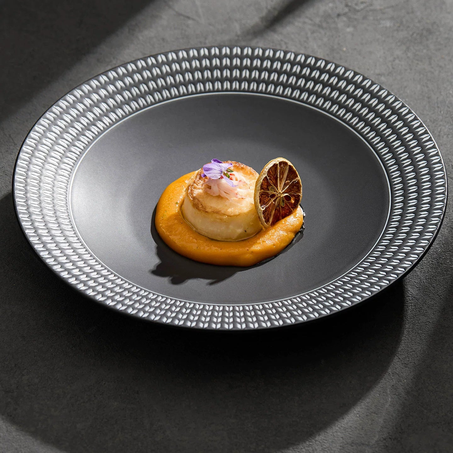 Modern shallow-bowl plate for fine dining, showcasing a high-contrast black and white pattern.