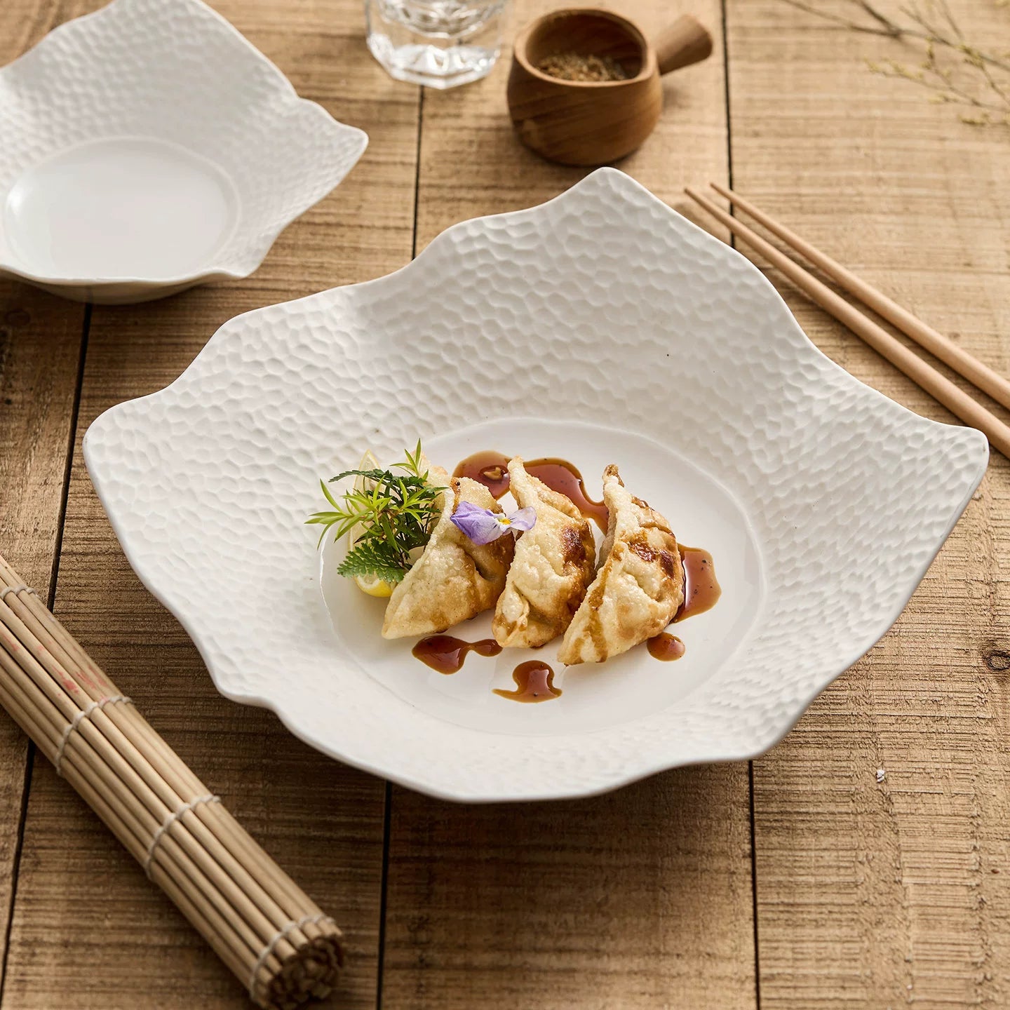 Off-white matte lattice irregular square plate with sculptural flared edges.