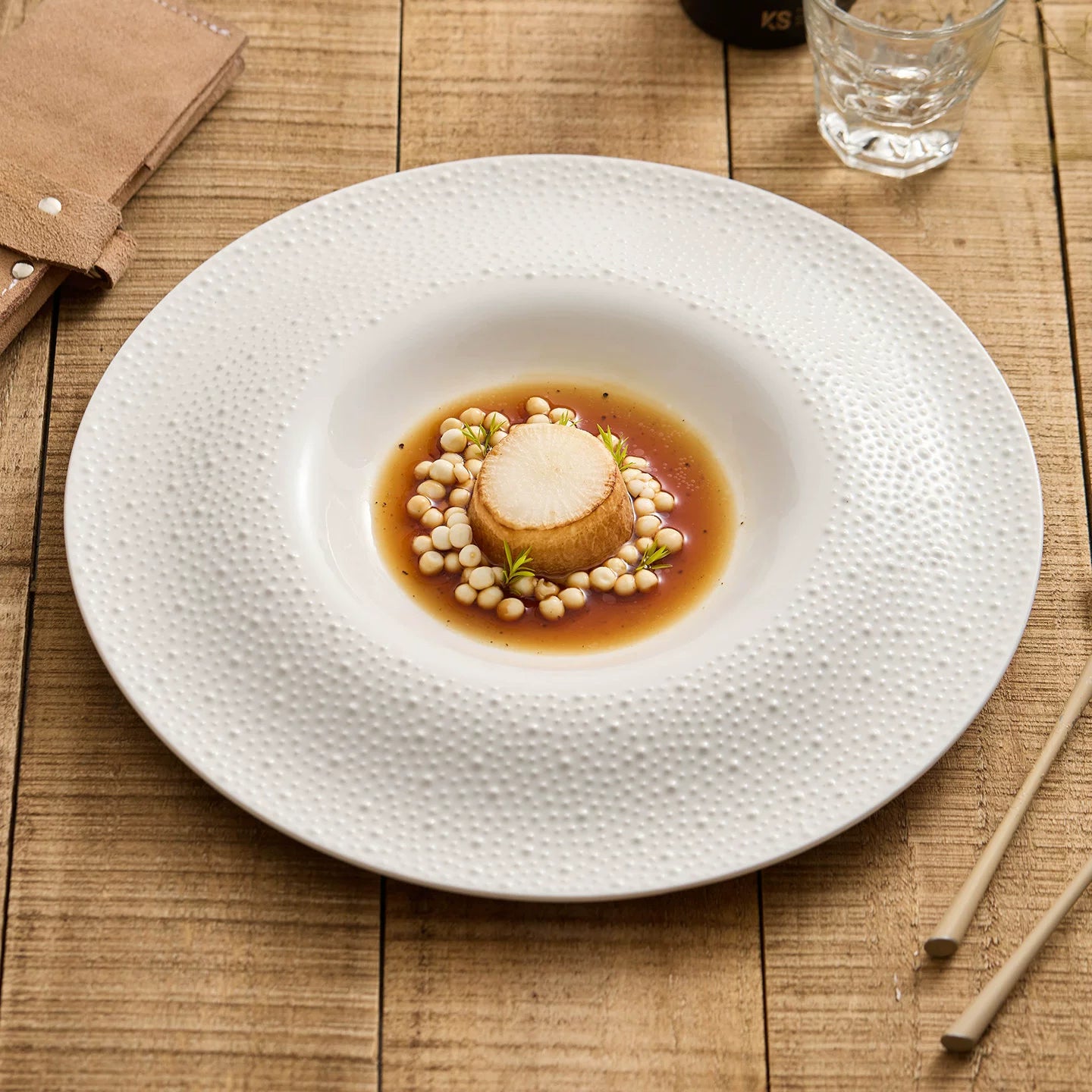 Off-white sesame point textured 12-inch round well plate.