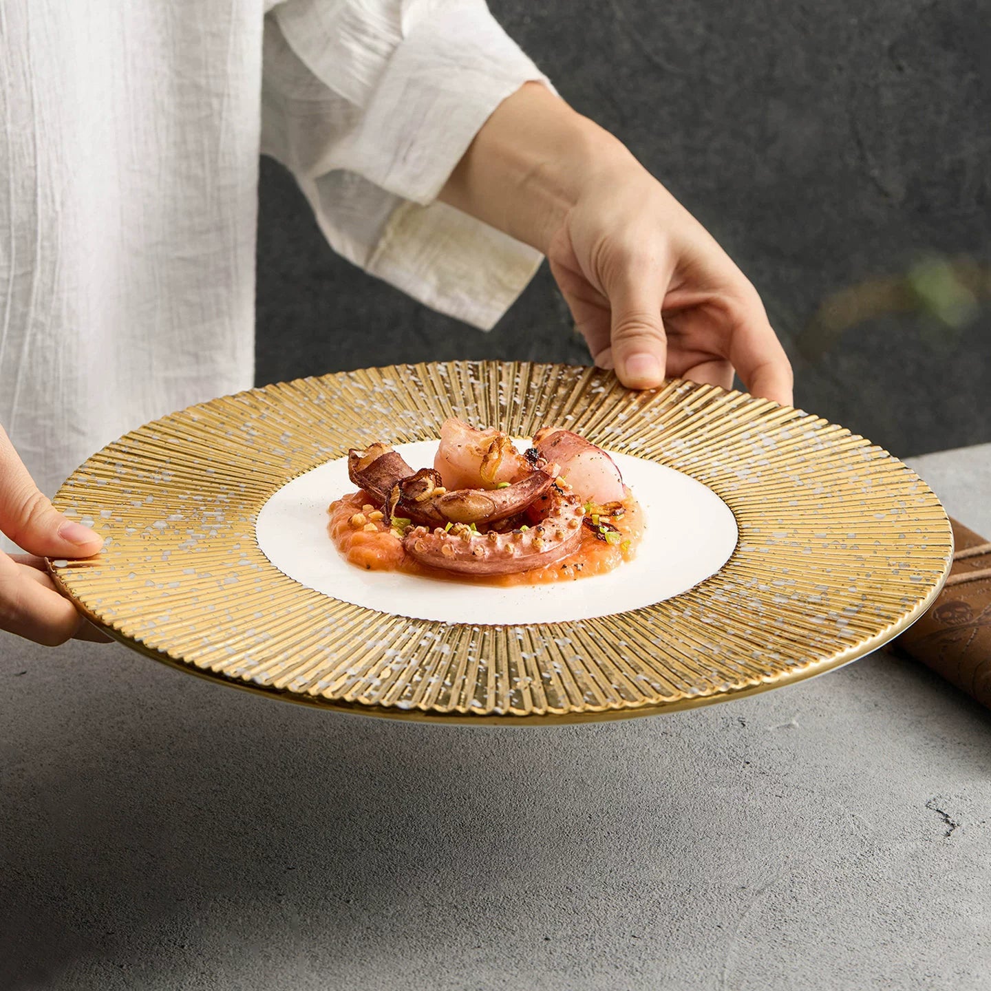 Professional 1116g weighted charger plate with gear-like golden radial pattern.