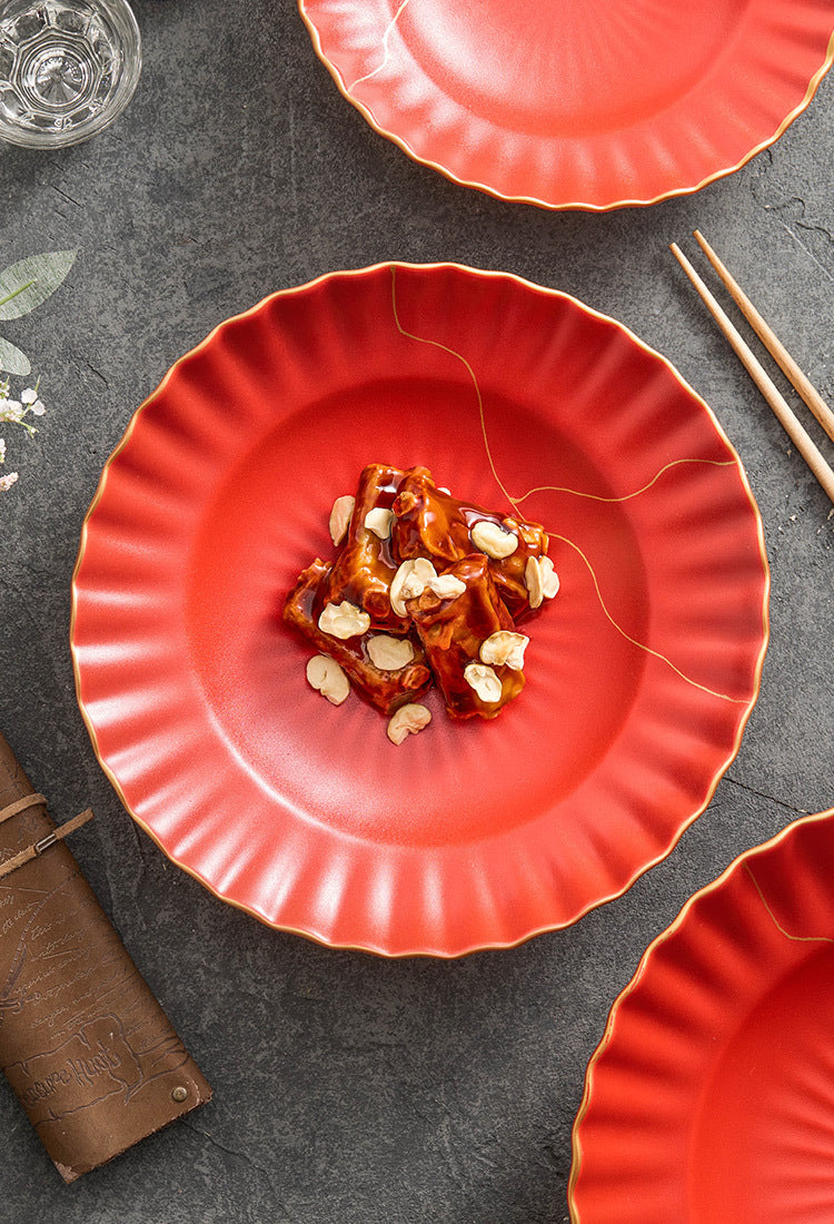 Red plate with food on a dark surface