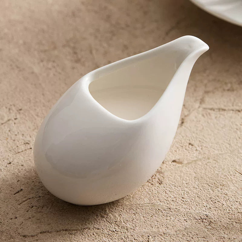 Sculptural matte white porcelain milk pitcher with precision eagle-mouth spout.
