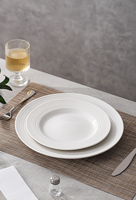 Shallow dining plate with softly textured rim for composed plating