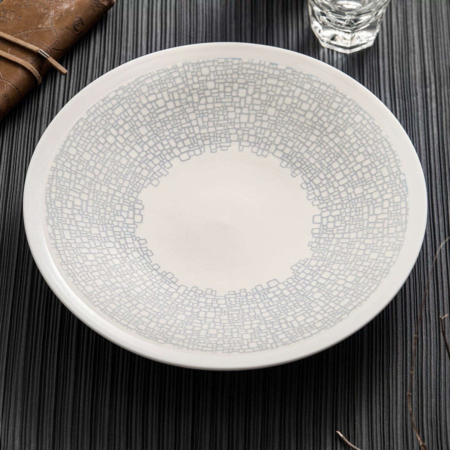 Side view of an architectural shallow-rimmed pasta bowl for fine dining.