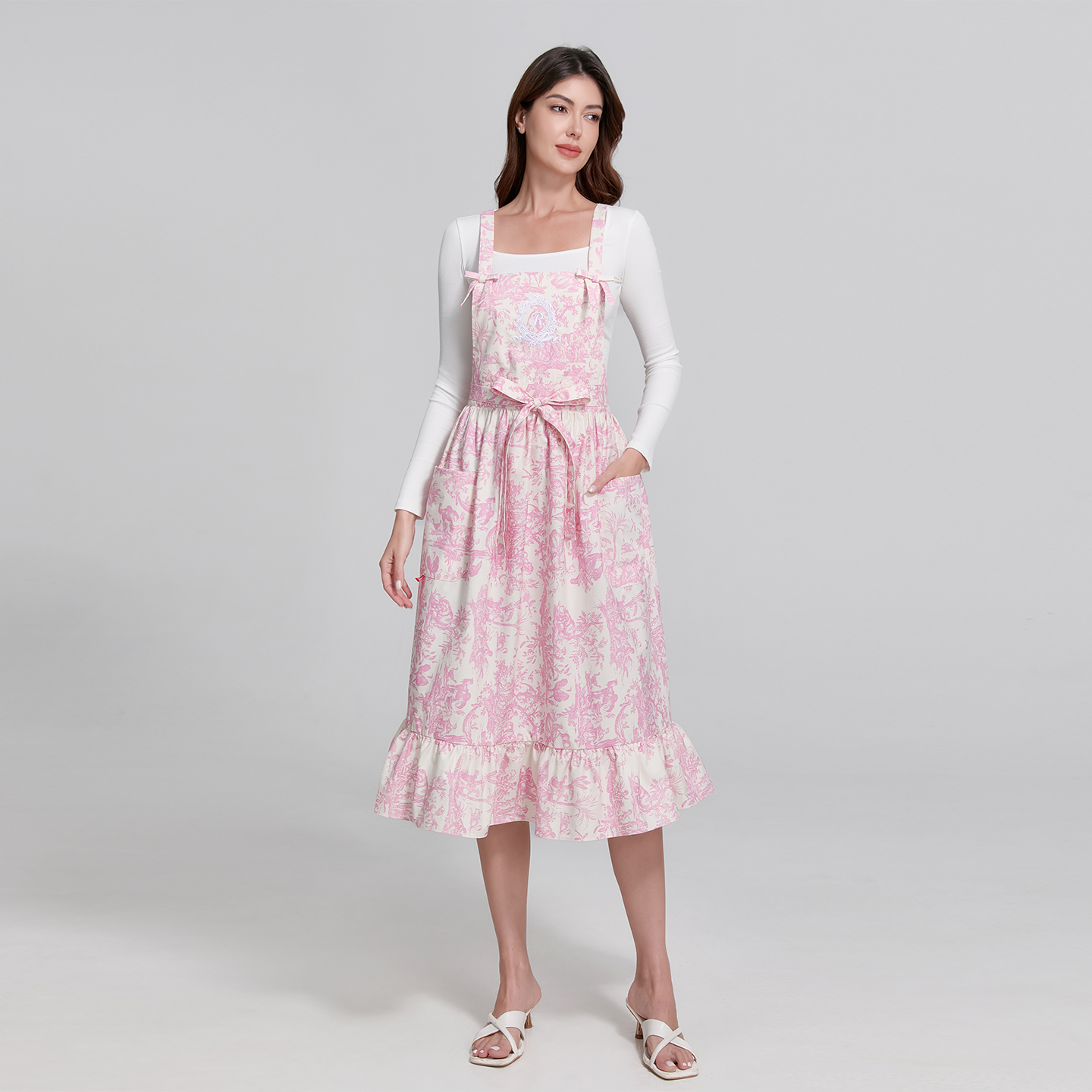 Sophisticated apron design featuring lovely ribbon trims and a graceful frill hemline in pink Toile de Jouy motif.