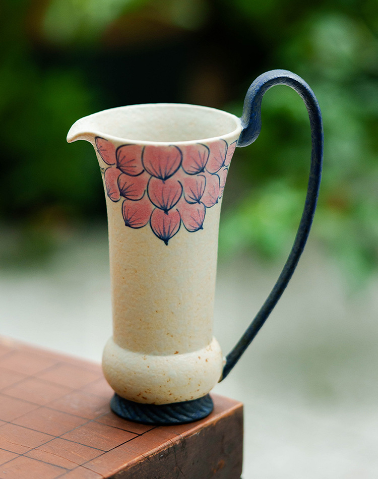 Speckled beige ceramic pitcher with delicate pink petals