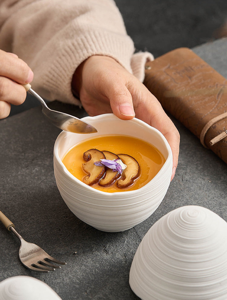 Steamed egg in modern ceramic bowl with lid on wooden table

