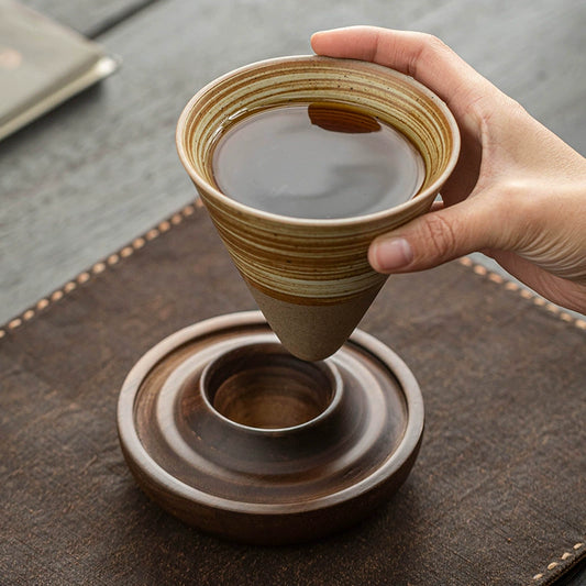 Textured ceramic coffee dripper on wooden saucer

