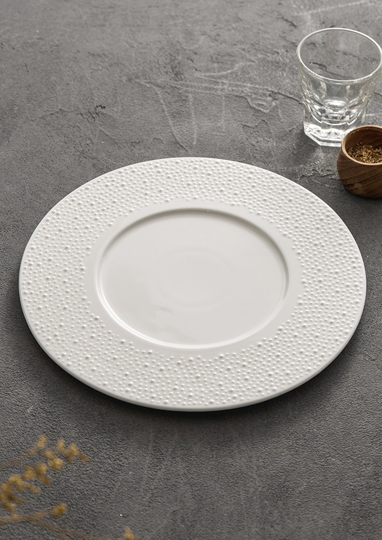Textured off-white porcelain plate with a 23.3cm base diameter for table stability.