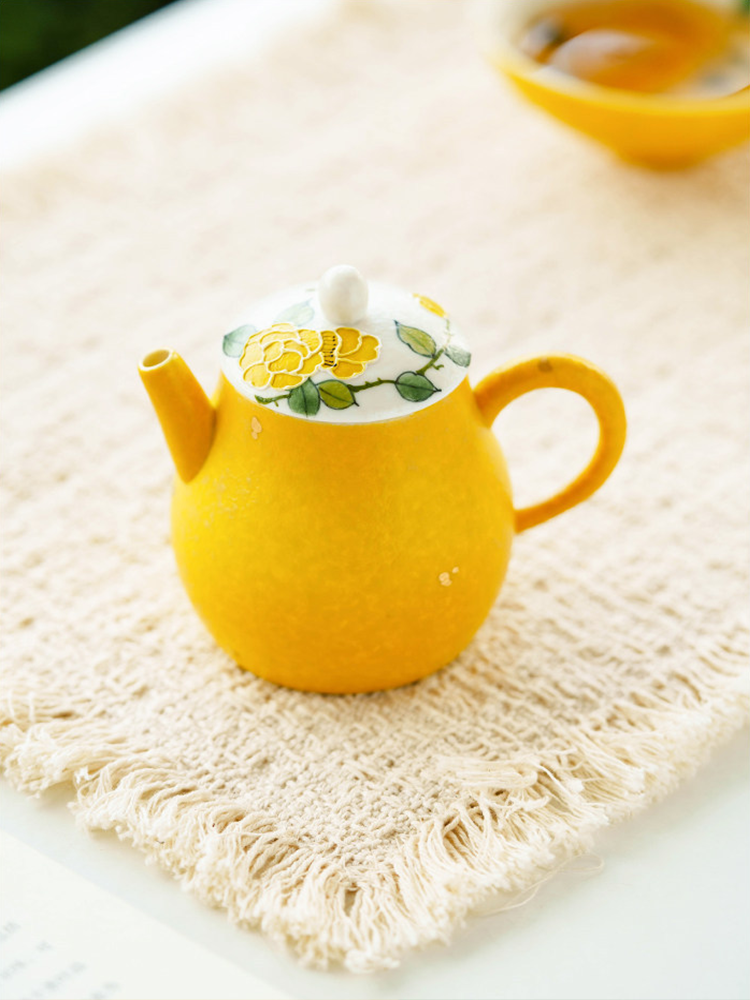Textured sun-yellow glaze on a high-fired porcelain teapot for a premium tactile grip.