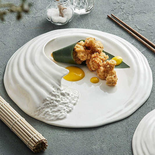 Top view of wave-shaped white ceramic plate on linen table

