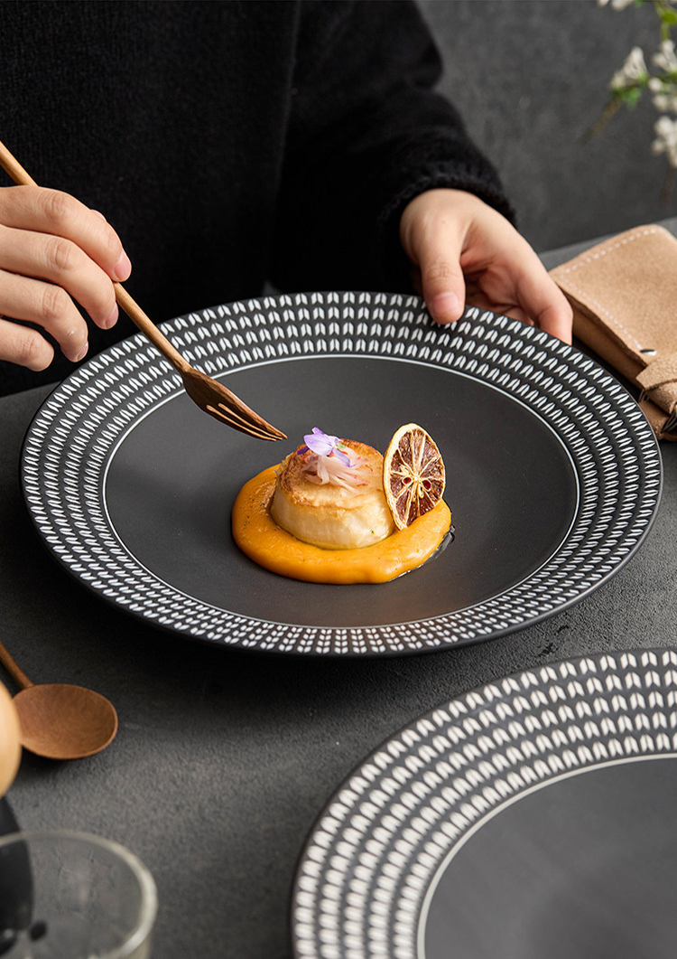 Vibrant culinary presentation on a dark ceramic canvas with a geometric patterned border.