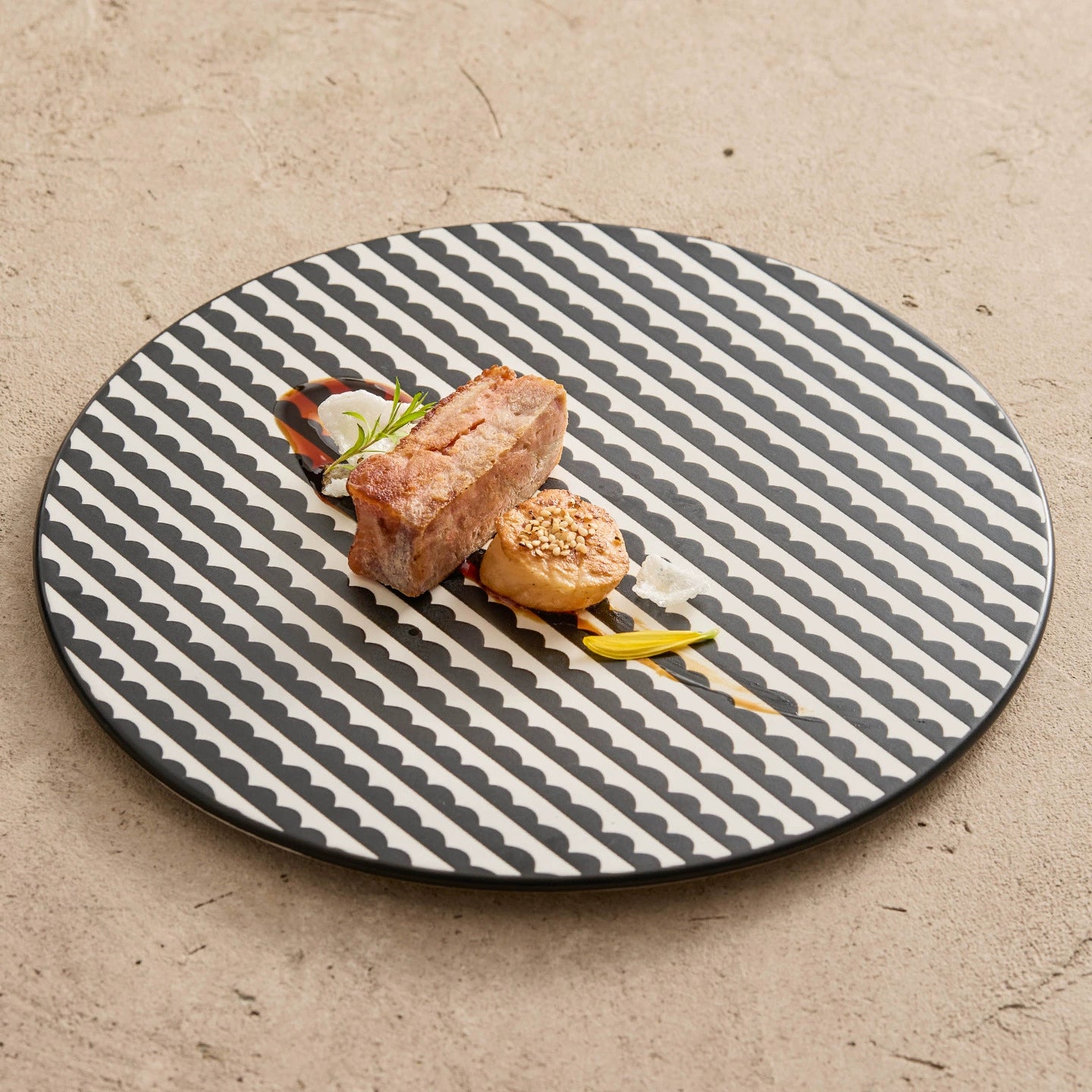 Dish with food on a round, patterned plate on a textured surface
