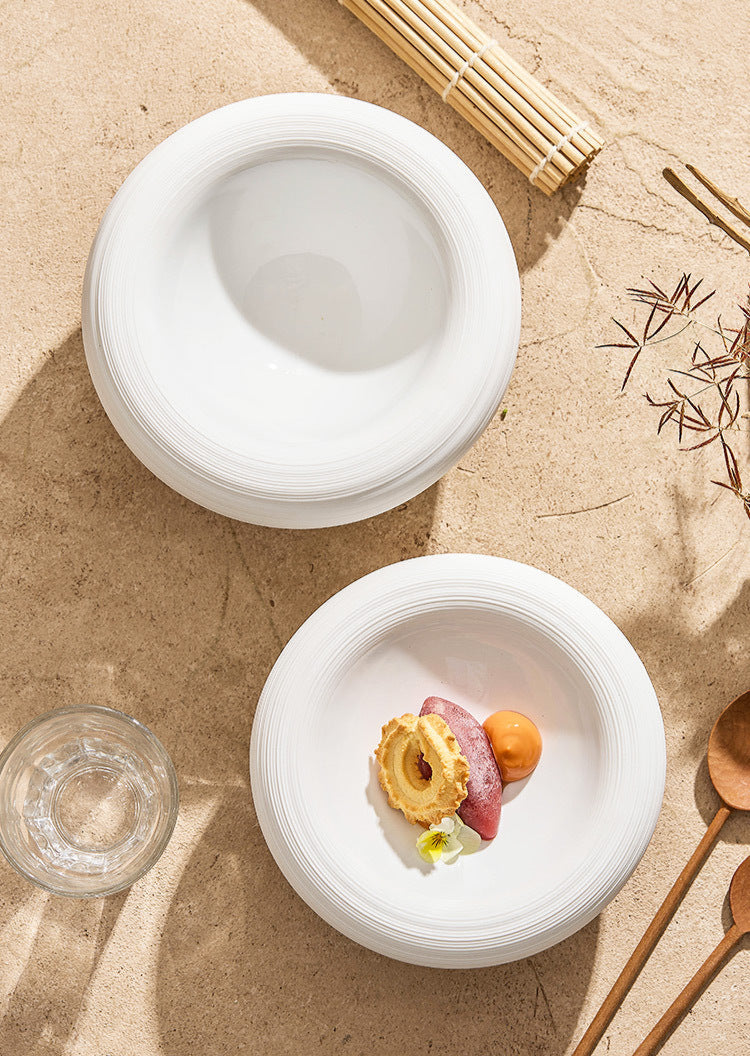 White ceramic bowl filled with creamy soup and garnishes

