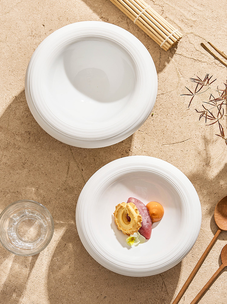 White ceramic bowl filled with creamy soup and garnishes