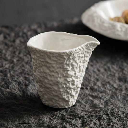 White ceramic sauce cup with rock-like textured surface

