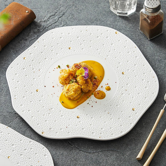 White porcelain dinner plate with organic wavy edge and gold dots