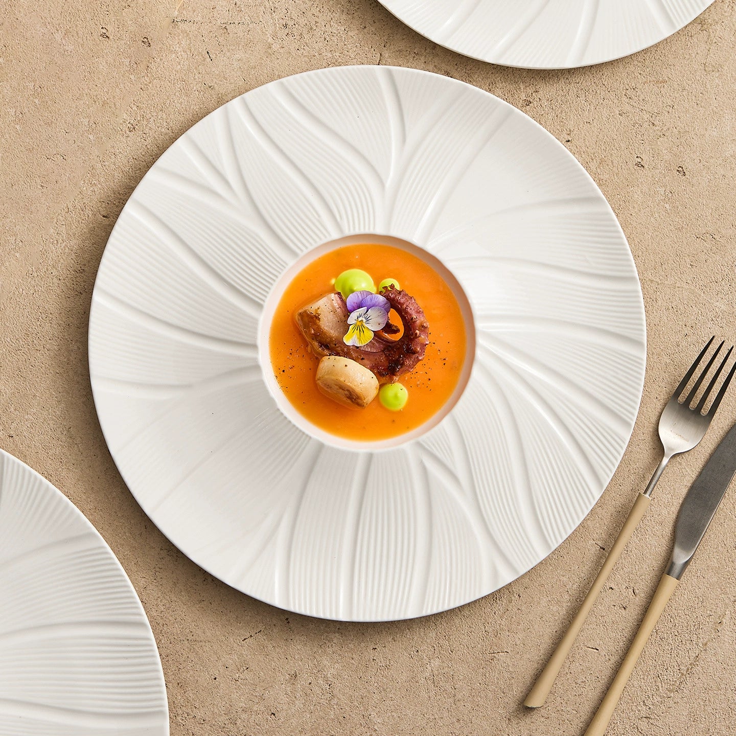 White porcelain plate with sculptural grooves and modern design.