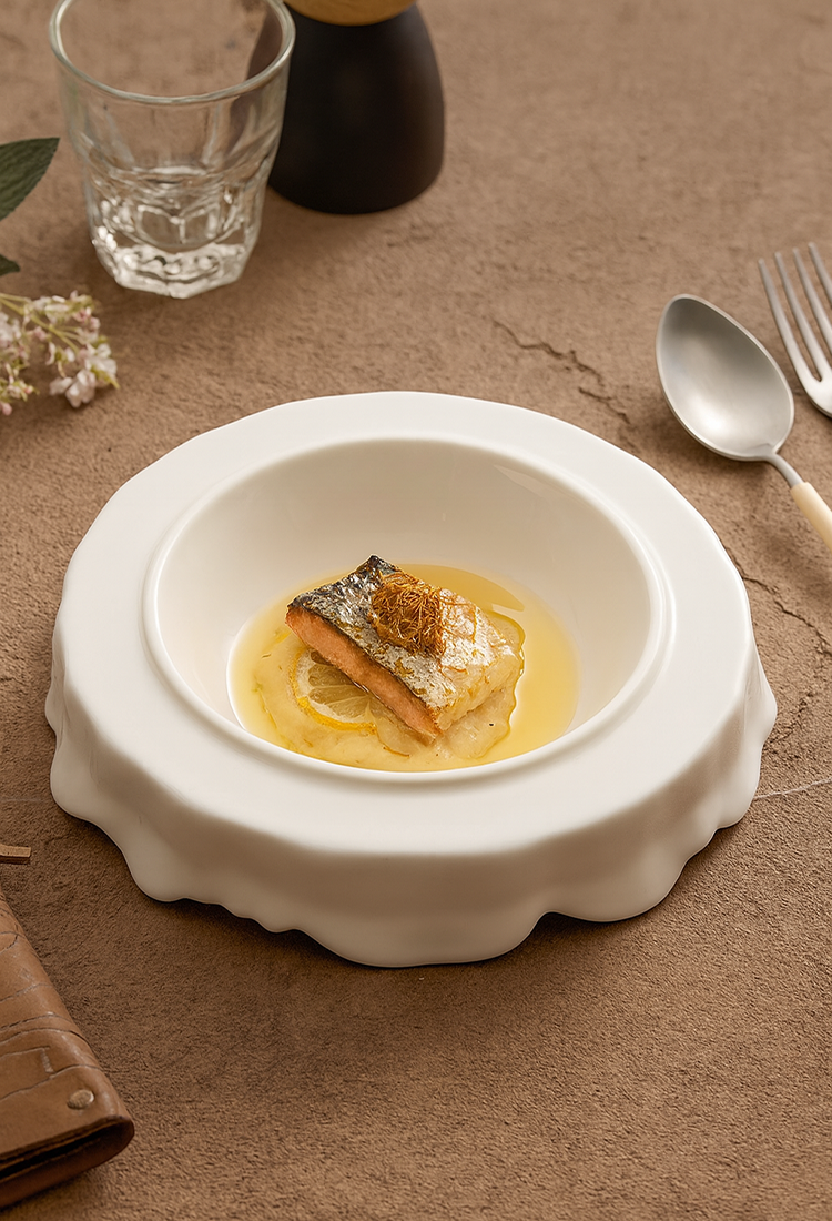 White sculpted tableware showcasing soft curved silhouette.