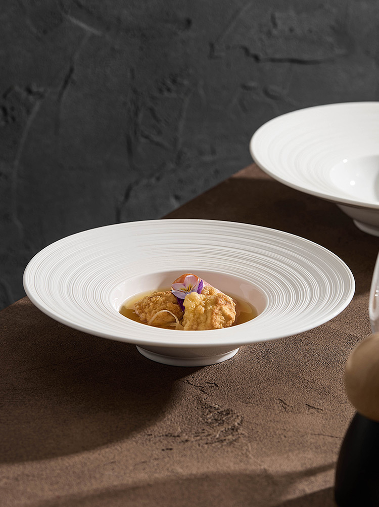 Wide-rim dining plate with concentric ripple design