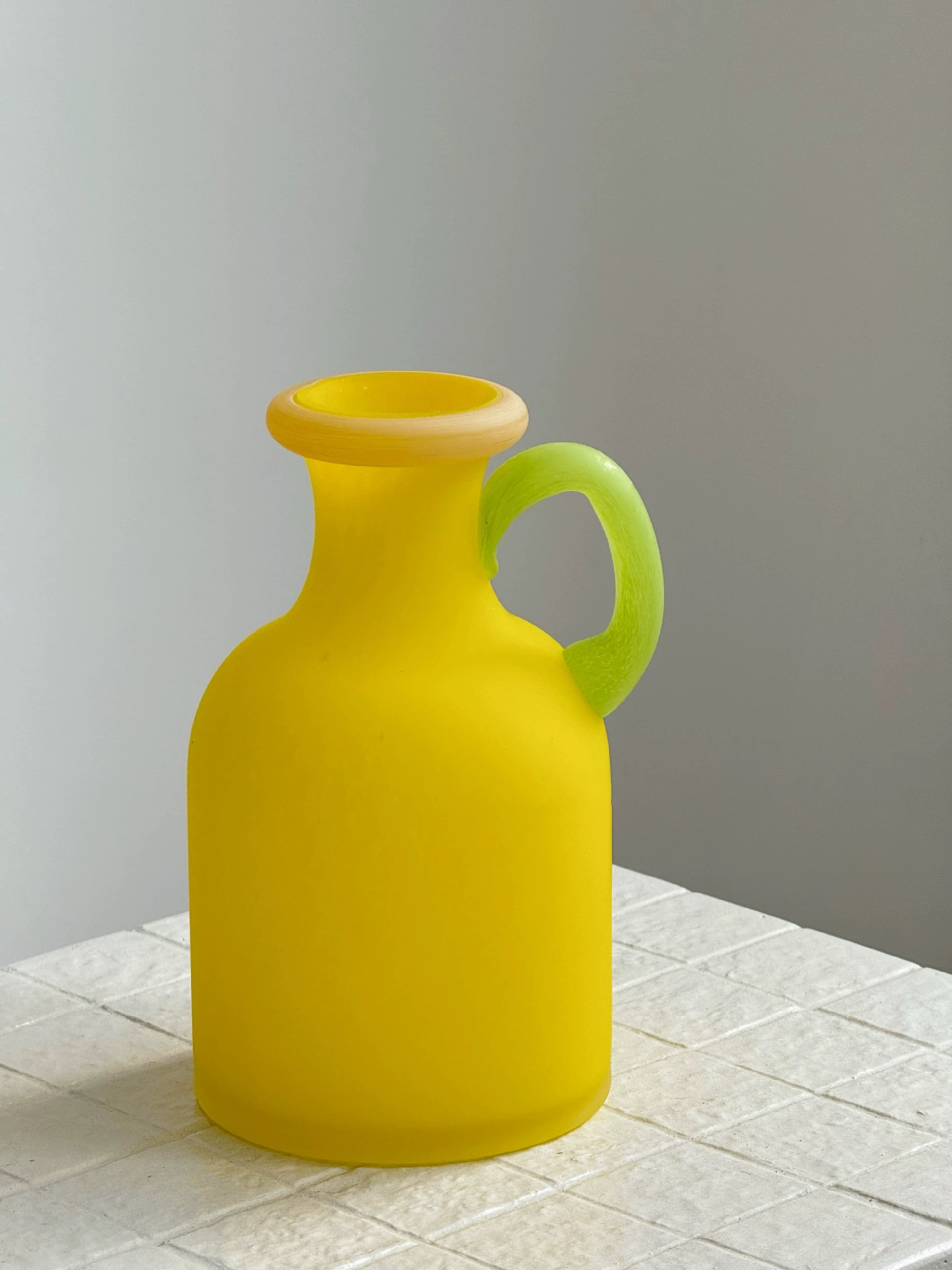 Yellow matte glass vase with artistic round handle