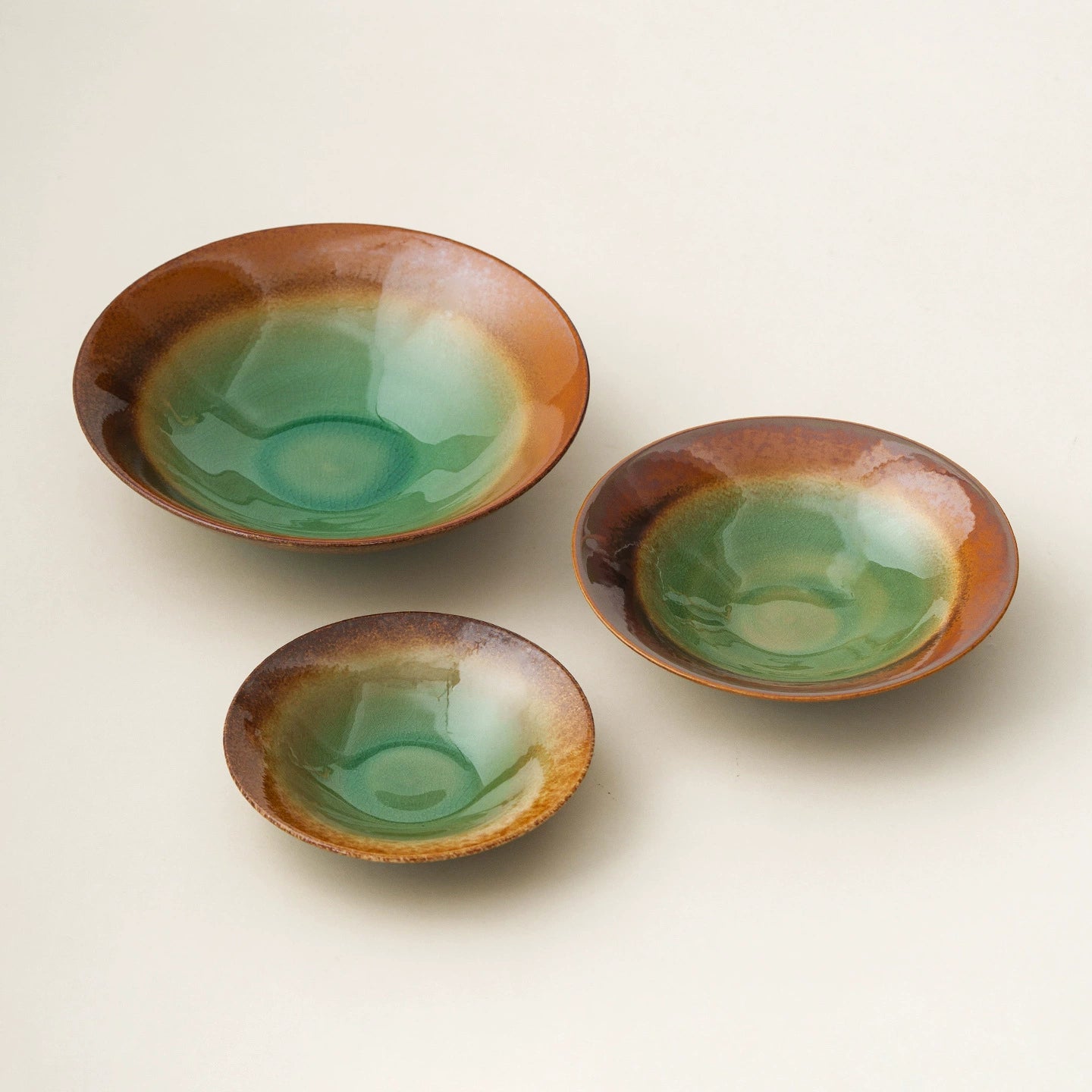 artisanal stoneware bowl with emerald green crackle glaze and brown rim