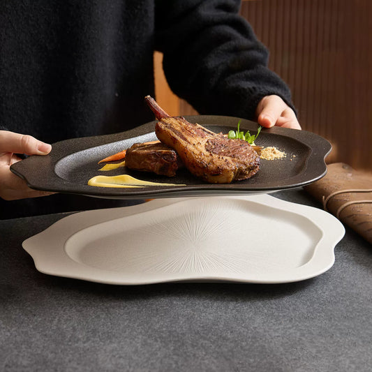 black matte irregular shaped dinner plate with lamb chops and sauce