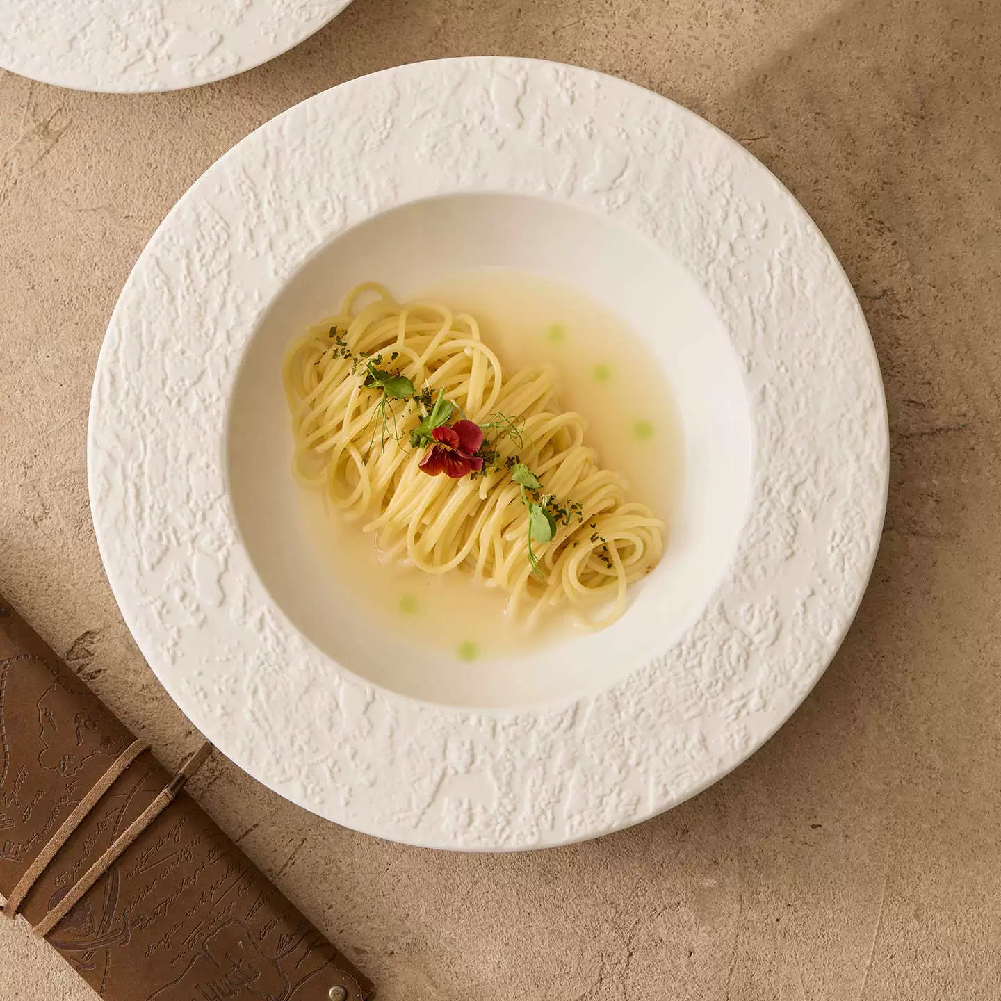pure white gourmet pasta bowl with textured sand border